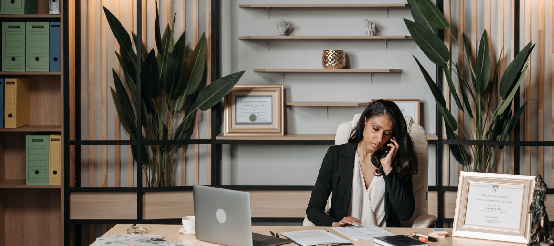 A woman sitting at her desk on the phone