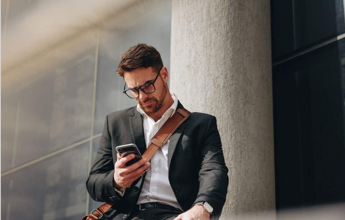 A man in suit and tie looking at his phone.