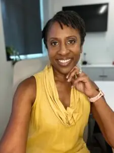 A woman in yellow shirt sitting at table.