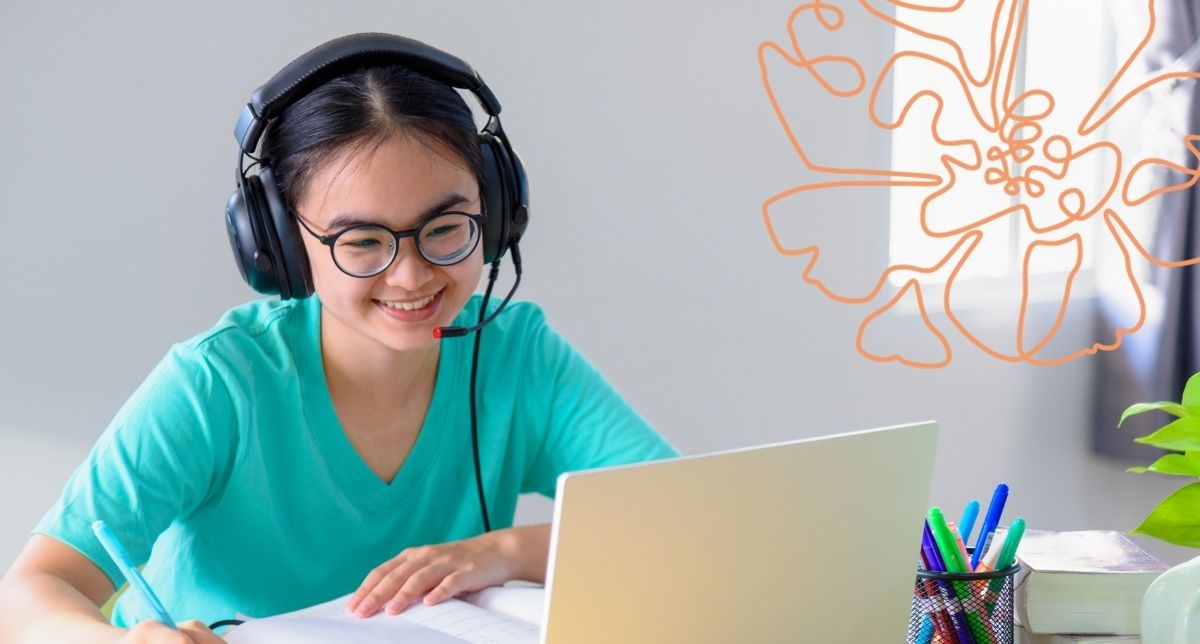 Asian American student smiling as she talks to someone on a video call.